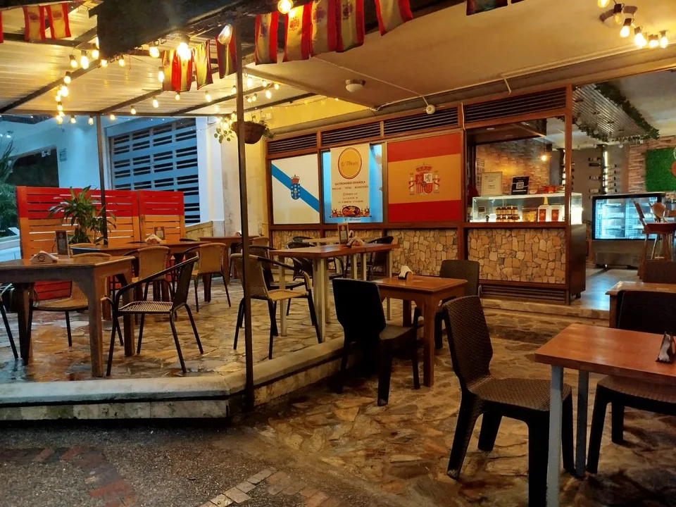 Terraza e interior de O’Lar DeMaría iluminados al anochecer